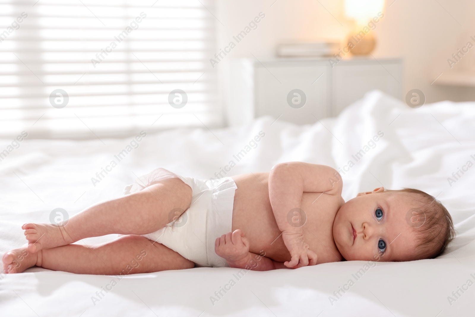 Cute newborn baby lying on bed indoors Photo of Cute newborn baby lying on bed indoors