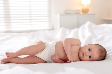 Photo of Cute newborn baby lying on bed indoors