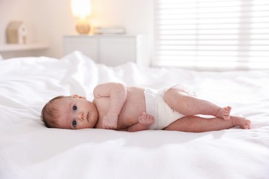 Photo of Cute newborn baby lying on bed indoors