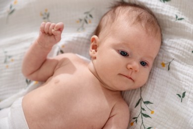 Photo of Cute newborn baby lying on bed, top view