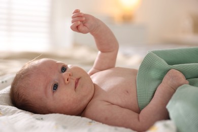 Photo of Cute newborn baby lying on bed, closeup