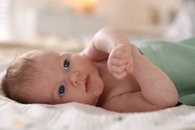 Photo of Cute newborn baby lying on bed, closeup