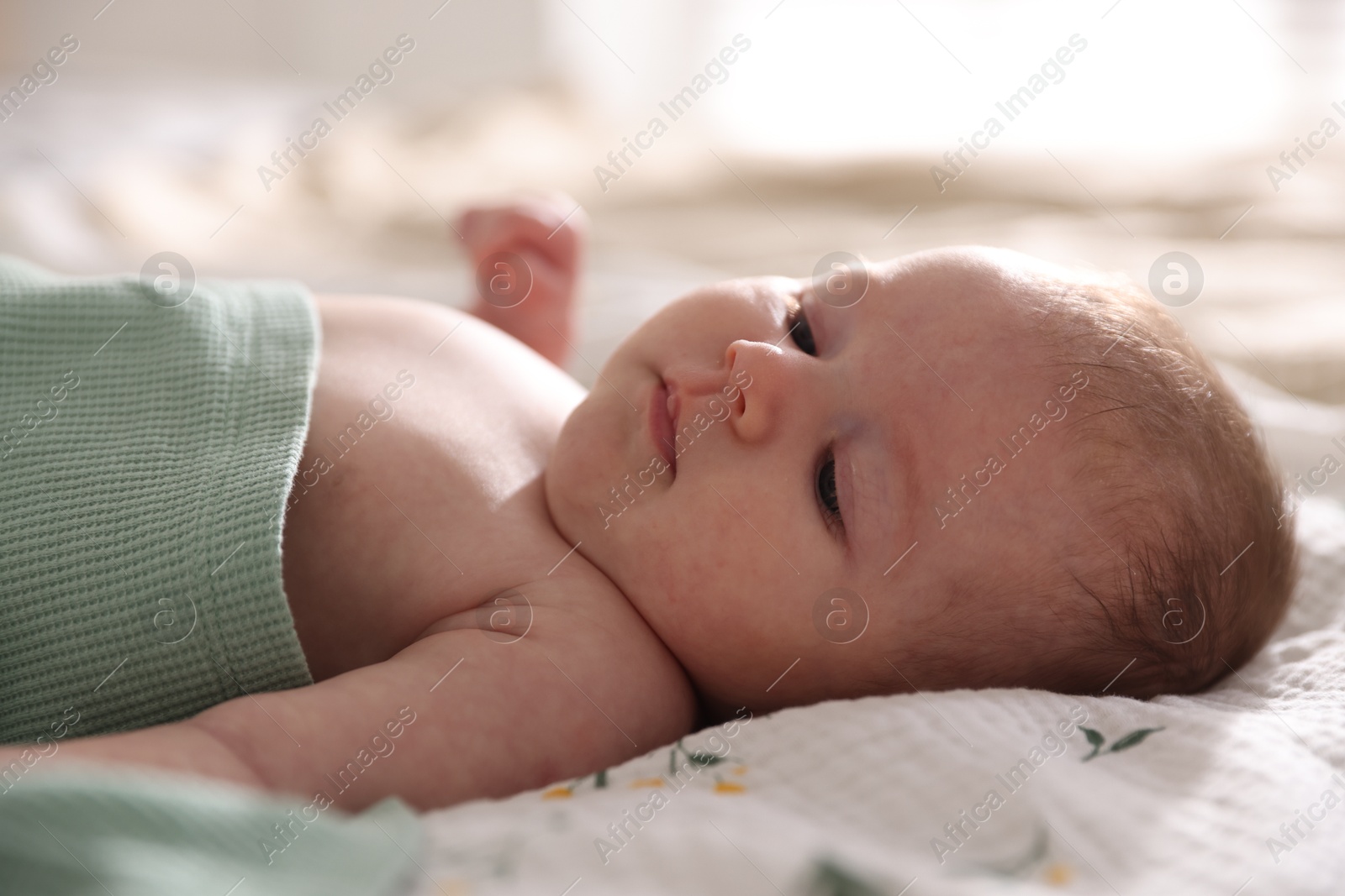 Cute newborn baby lying on bed, closeup Photo of Cute newborn baby lying on bed, closeup