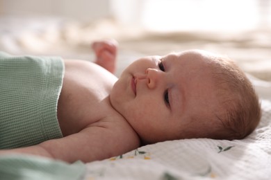 Photo of Cute newborn baby lying on bed, closeup
