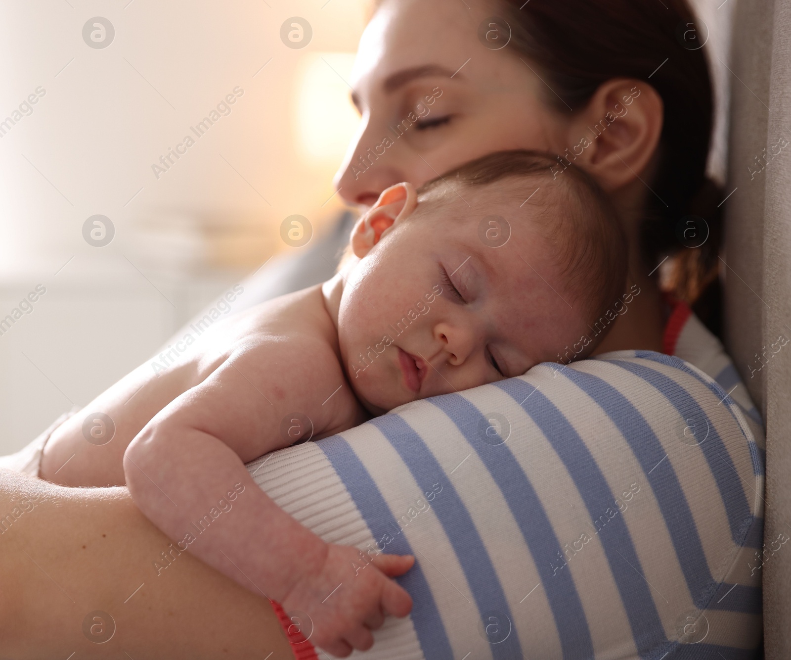 Mother putting her cute newborn baby to sleep at home, closeup Photo of Mother putting her cute newborn baby to sleep at home, closeup