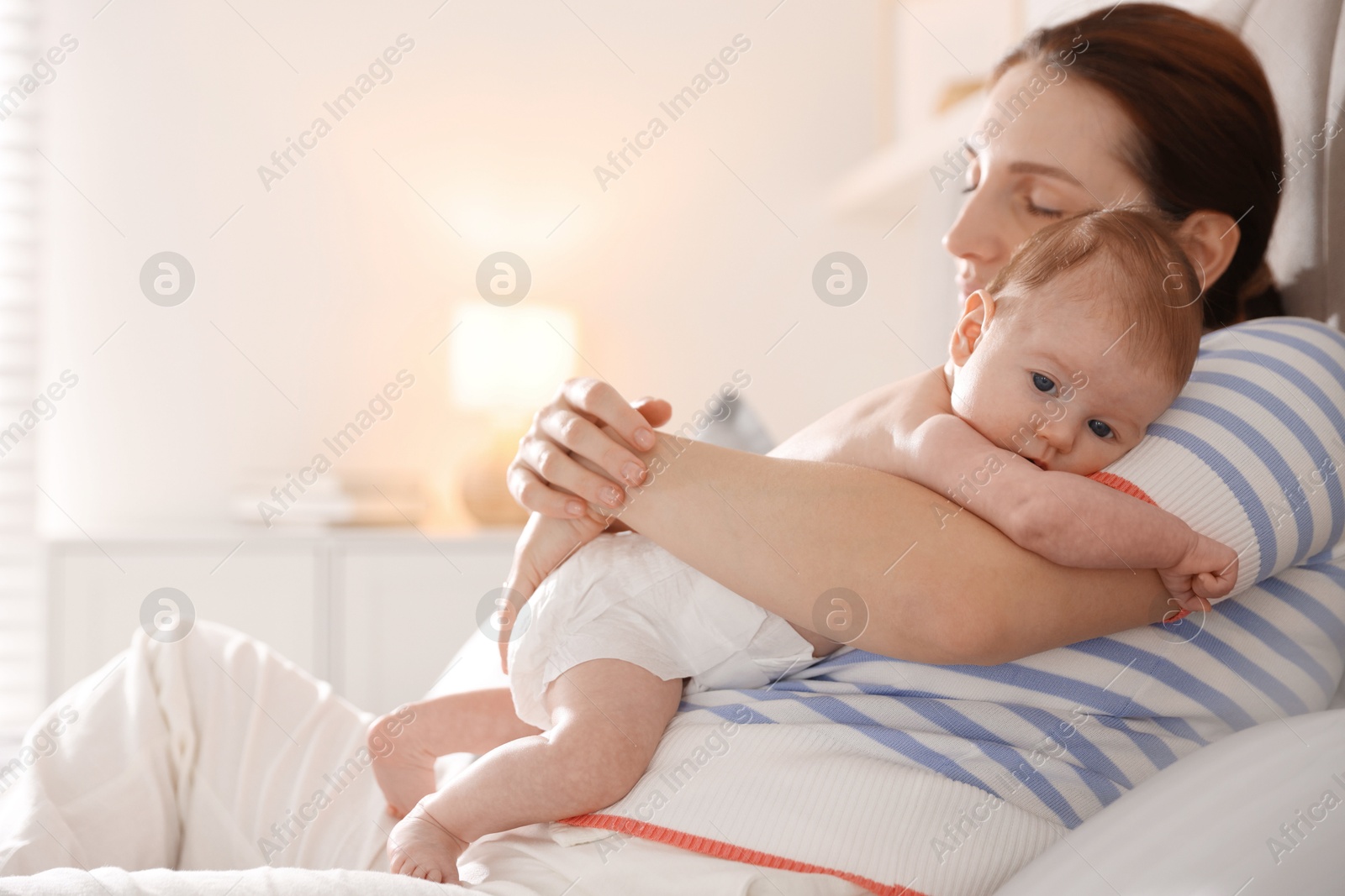 Mother putting her cute newborn baby to sleep at home Photo of Mother putting her cute newborn baby to sleep at home