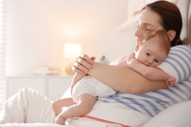 Photo of Mother putting her cute newborn baby to sleep at home