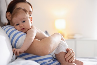 Photo of Mother putting her cute newborn baby to sleep at home