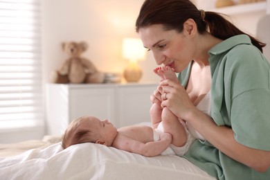 Photo of Mother with her cute newborn baby on bed at home