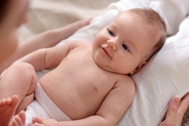 Photo of Mother putting her cute newborn baby to sleep on bed at home, above view