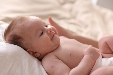 Photo of Mother putting her cute newborn baby to sleep on bed at home