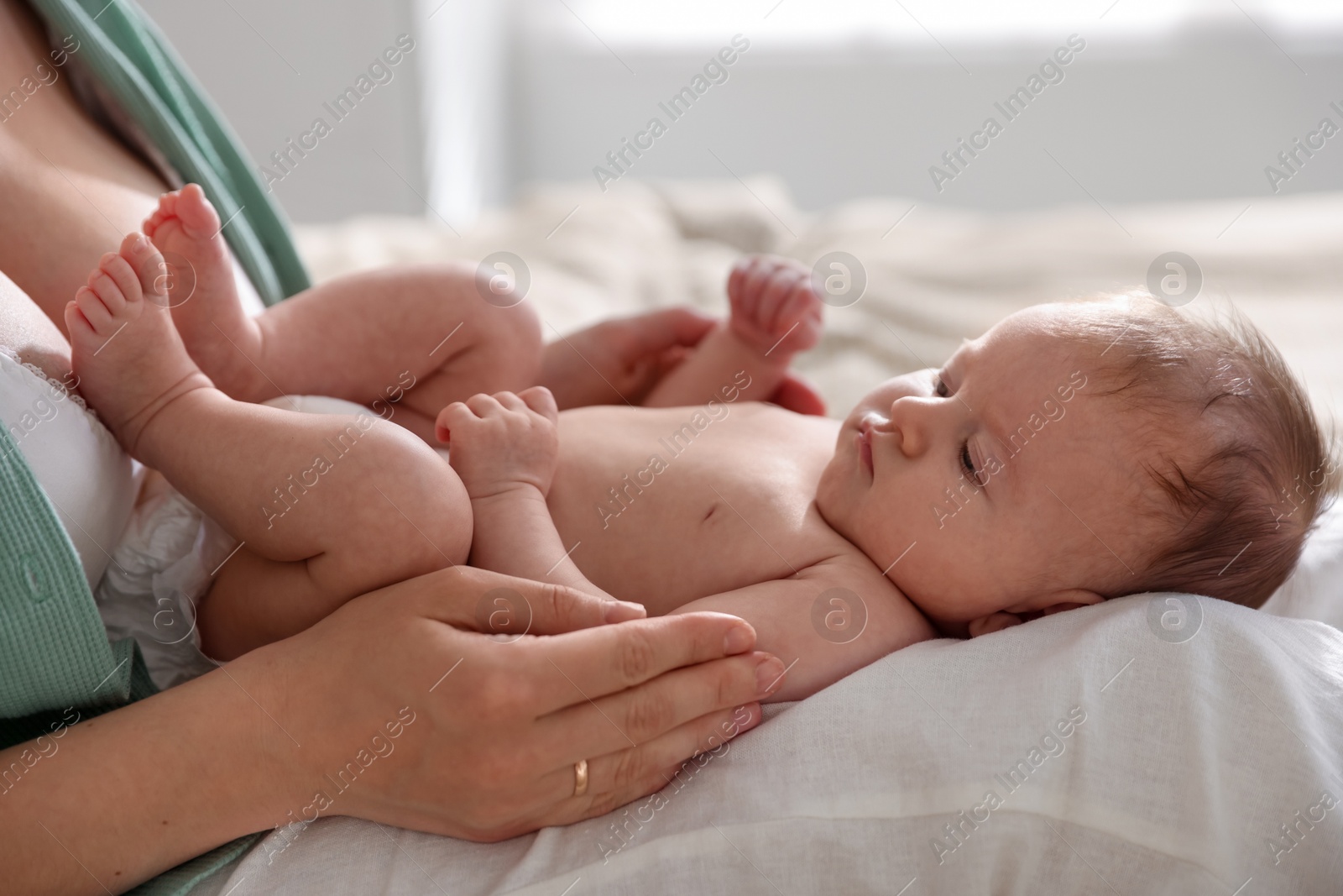 Mother putting her cute newborn baby to sleep at home, closeup Photo of Mother putting her cute newborn baby to sleep at home, closeup