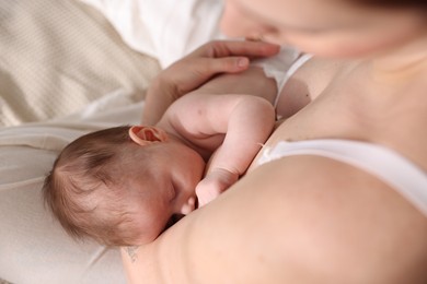 Photo of Mother breastfeeding her newborn baby indoors, above view