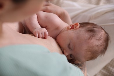 Photo of Mother breastfeeding her newborn baby indoors, above view
