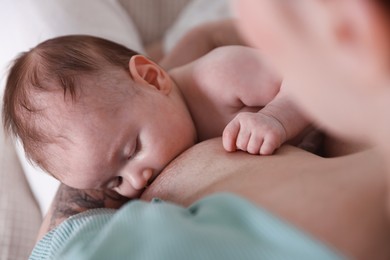 Photo of Mother breastfeeding her newborn baby indoors, above view