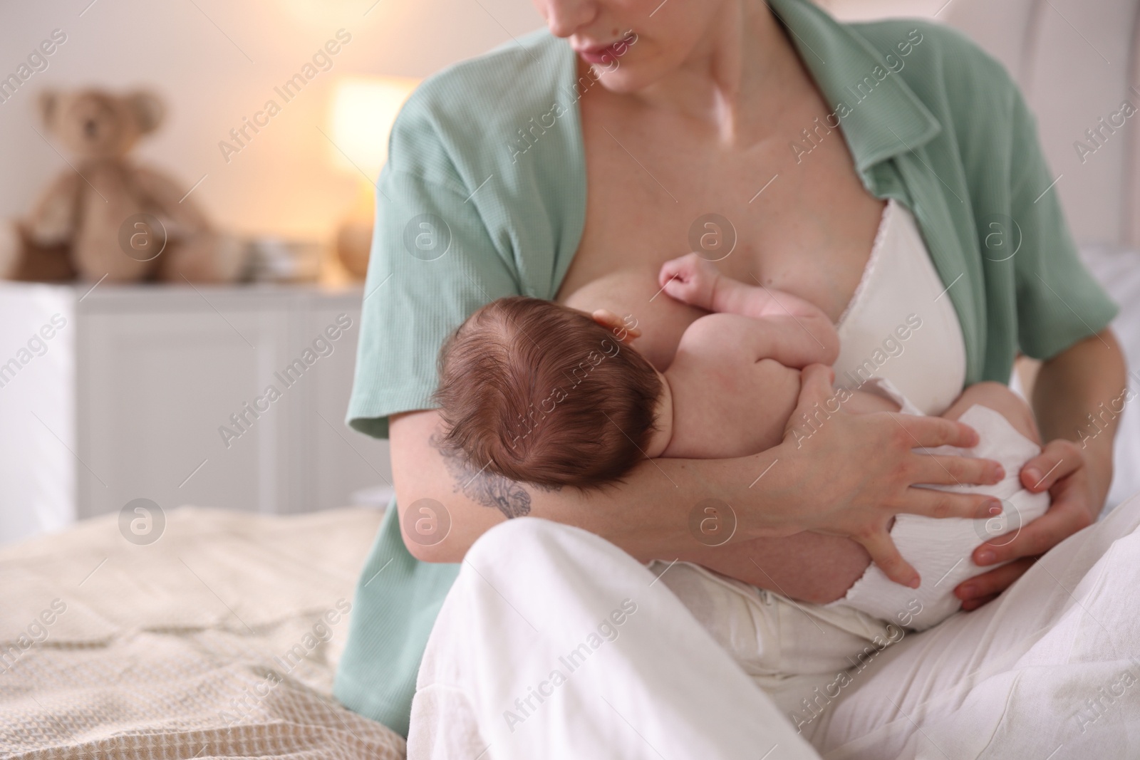 Mother breastfeeding her newborn baby indoors, closeup Photo of Mother breastfeeding her newborn baby indoors, closeup