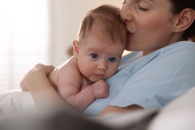 Photo of Mother putting her cute newborn baby to sleep at home, closeup