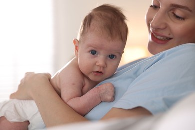Photo of Mother putting her cute newborn baby to sleep at home, closeup