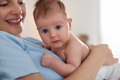 Photo of Mother putting her cute newborn baby to sleep at home, closeup