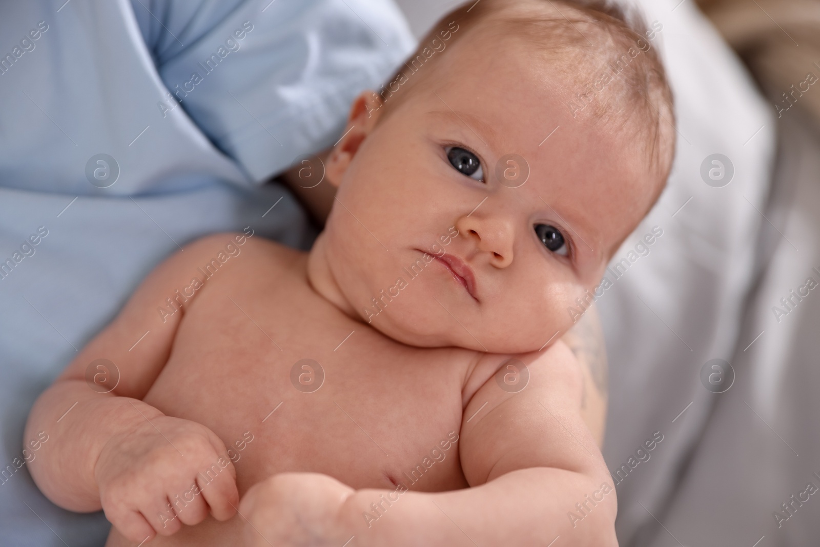 Mother with her cute newborn baby on bed at home, above view Photo of Mother with her cute newborn baby on bed at home, above view