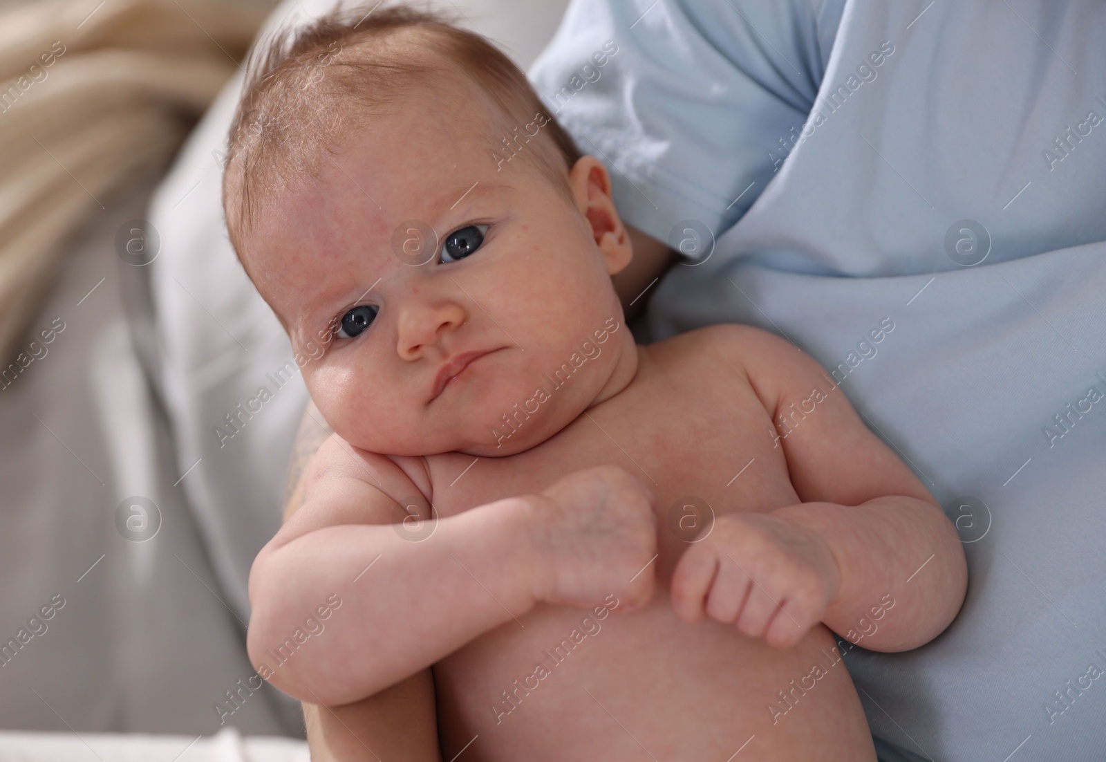 Mother with her cute newborn baby on bed at home, above view Photo of Mother with her cute newborn baby on bed at home, above view