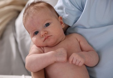 Photo of Mother with her cute newborn baby on bed at home, above view