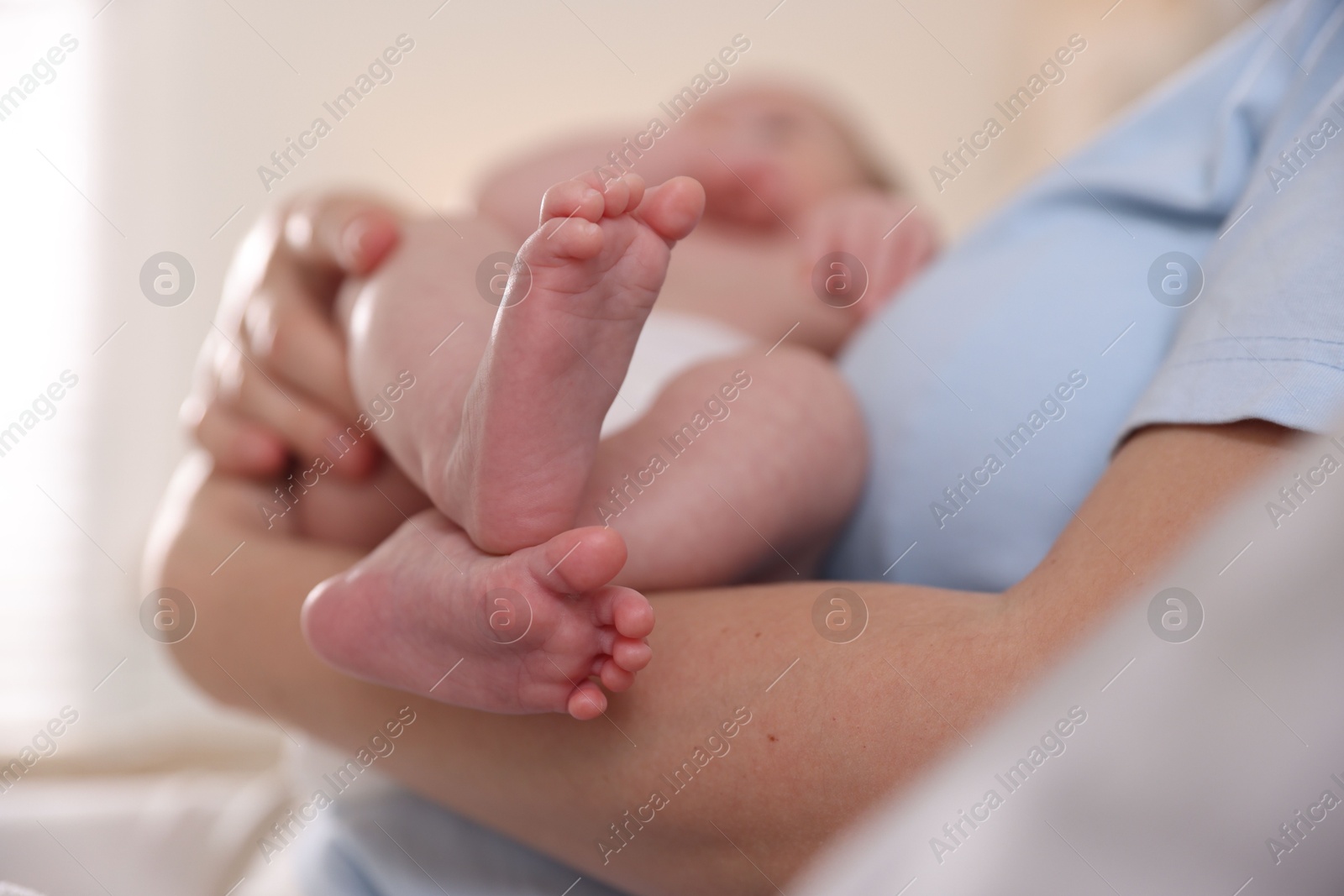 Mother putting her cute newborn baby to sleep at home, closeup Photo of Mother putting her cute newborn baby to sleep at home, closeup
