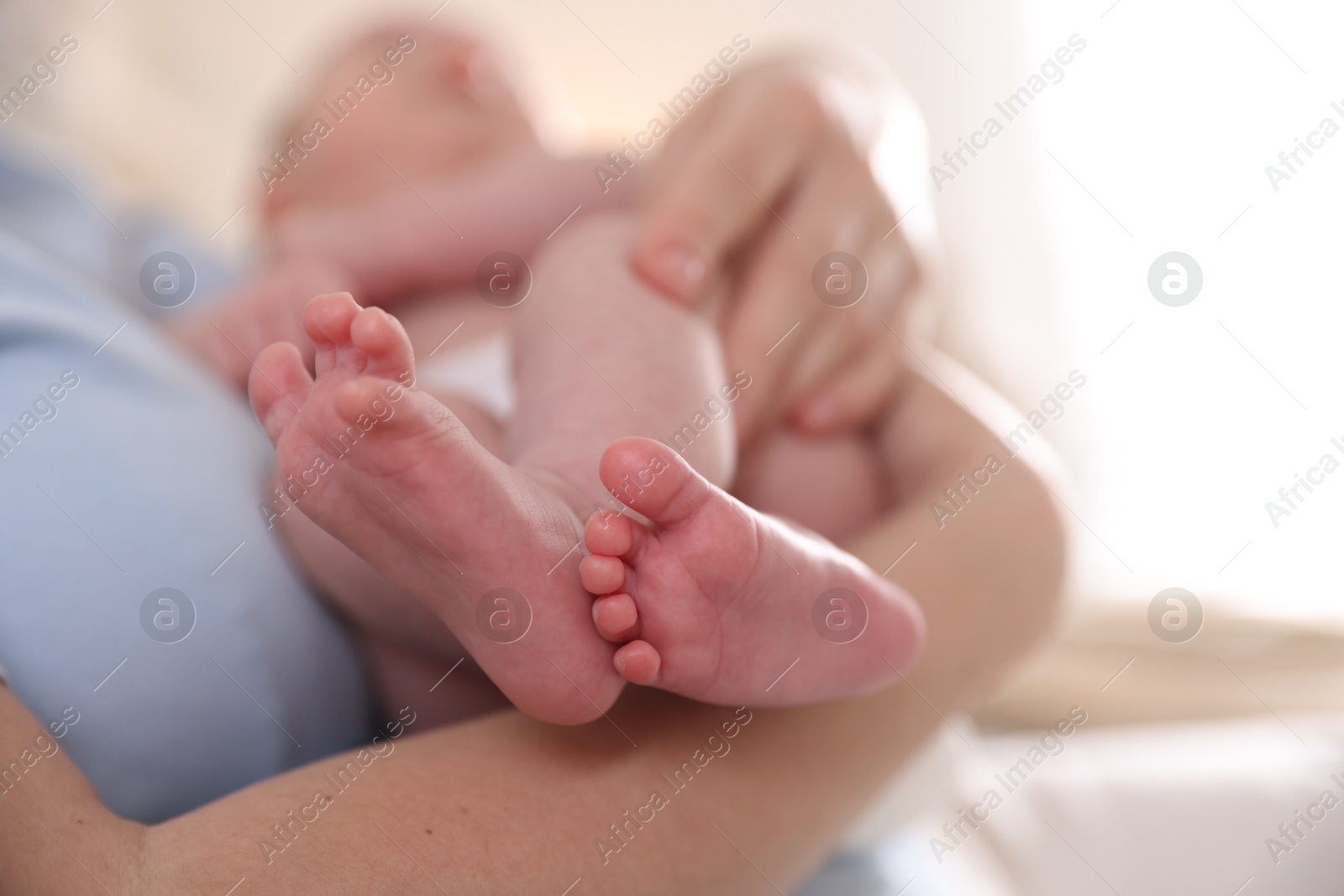 Mother putting her cute newborn baby to sleep at home, closeup Photo of Mother putting her cute newborn baby to sleep at home, closeup