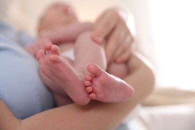 Photo of Mother putting her cute newborn baby to sleep at home, closeup