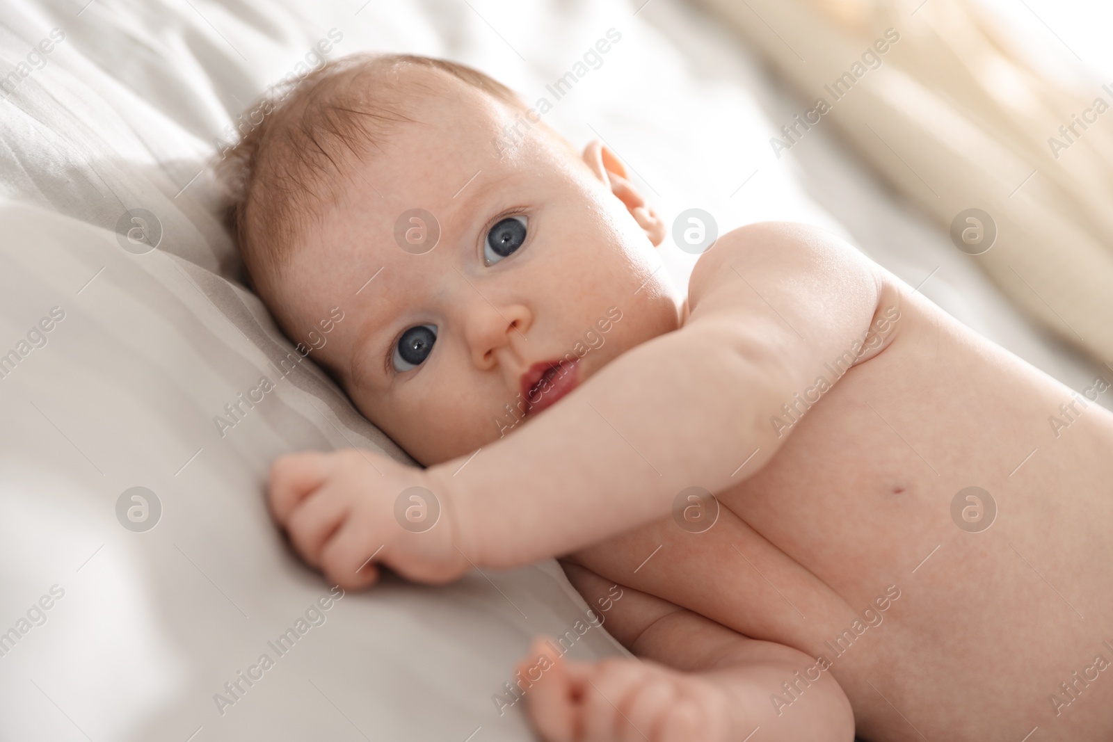 Photo of Cute newborn baby lying on bed, closeup