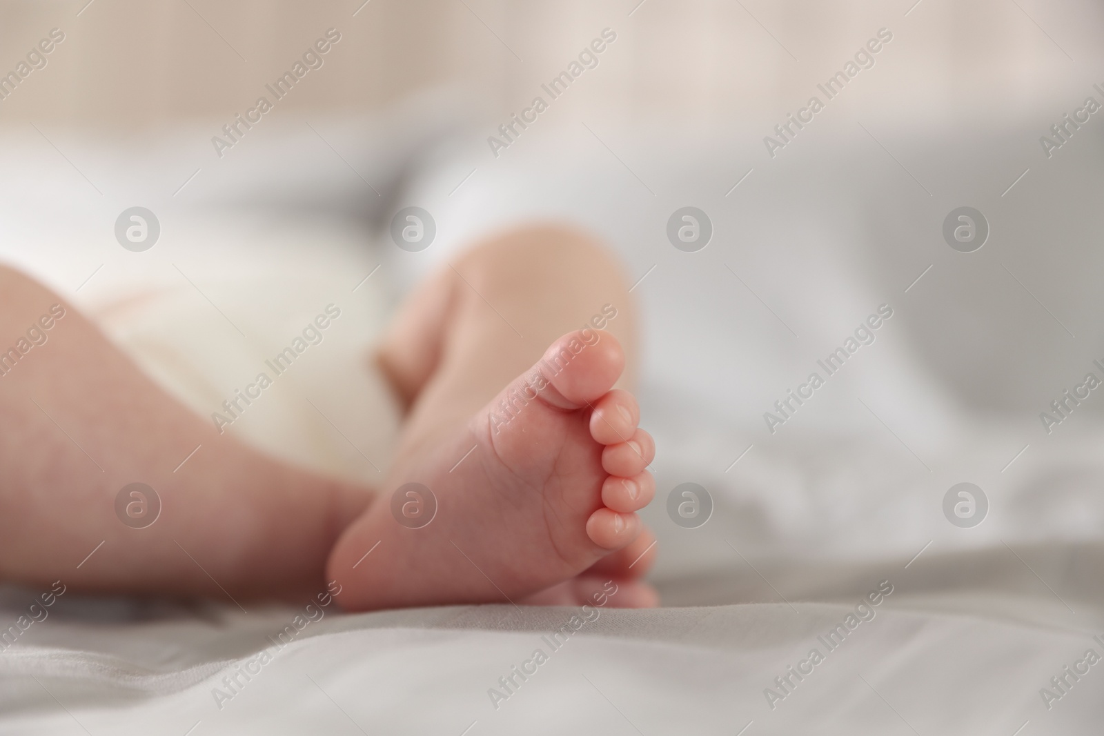 Photo of Cute newborn baby lying on bed, closeup. Space for text