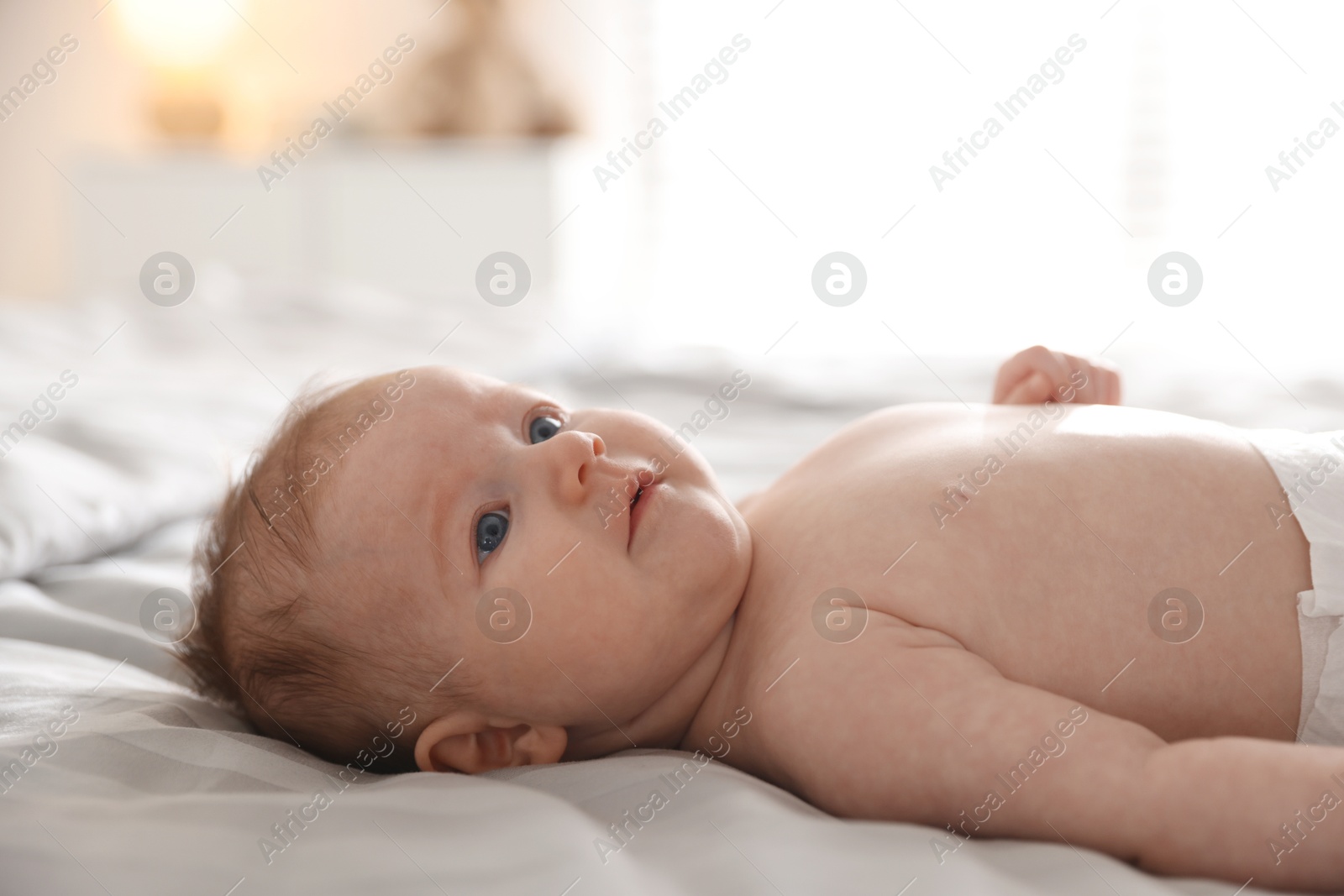 Cute newborn baby lying on bed, closeup Photo of Cute newborn baby lying on bed, closeup