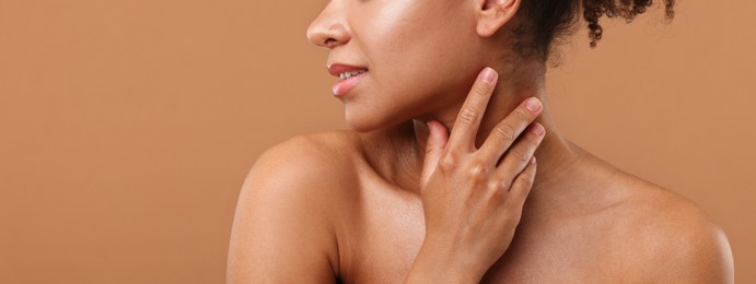 Photo of Brazilian woman after spa treatment on light brown background, closeup. Space for text