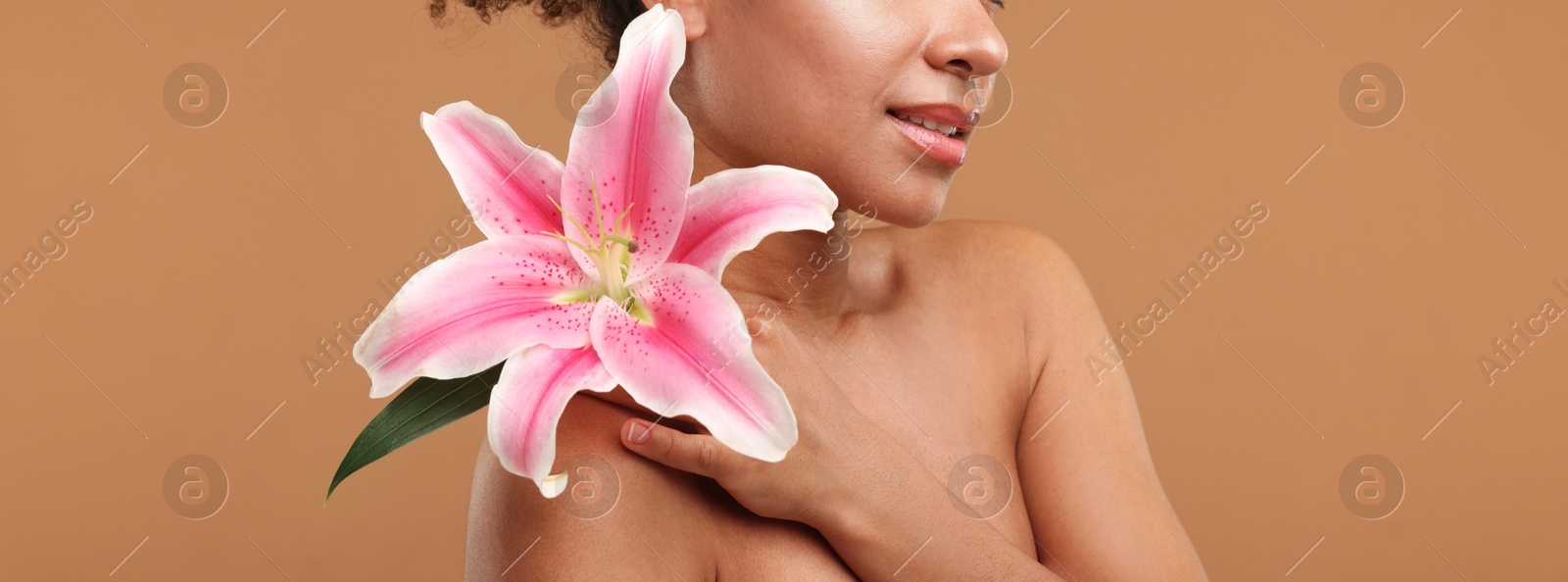 Brazilian woman with lily flower after spa treatment on light brown background, closeup Photo of Brazilian woman with lily flower after spa treatment on light brown background, closeup
