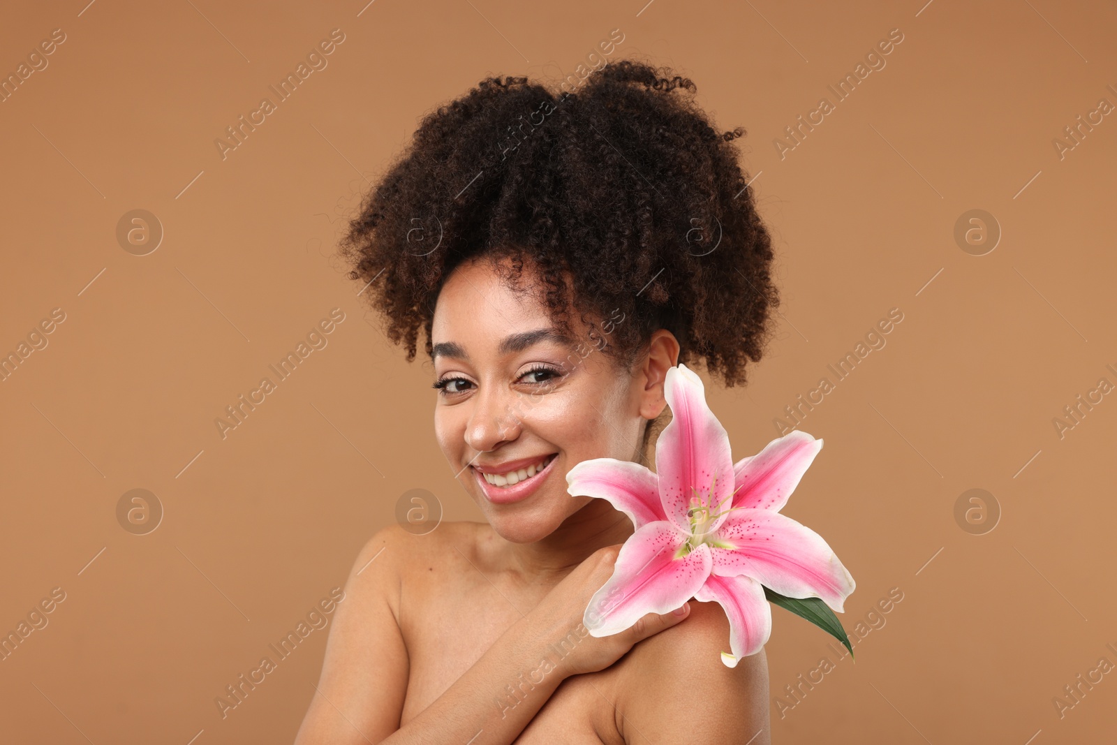 Portrait of beautiful Brazilian woman with lily flower after spa treatment on light brown background Photo of Portrait of beautiful Brazilian woman with lily flower after spa treatment on light brown background