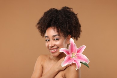 Photo of Portrait of beautiful Brazilian woman with lily flower after spa treatment on light brown background