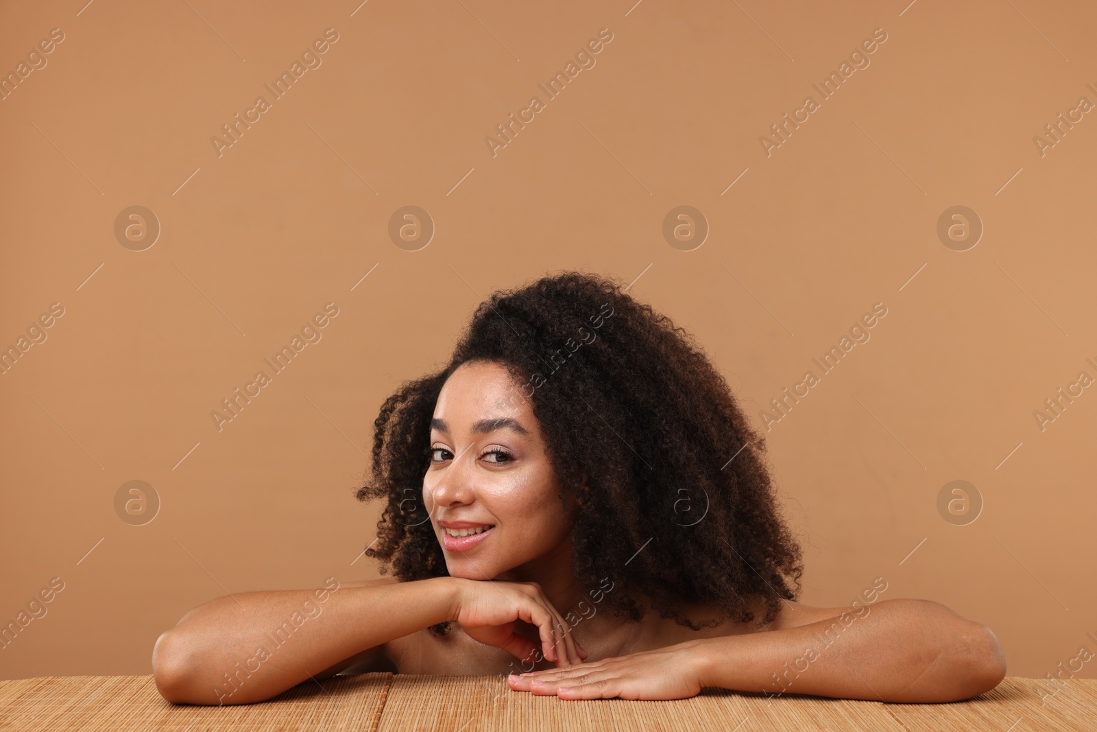 Portrait of beautiful Brazilian woman after spa treatment at bamboo table on beige background Photo of Portrait of beautiful Brazilian woman after spa treatment at bamboo table on beige background