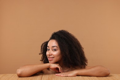 Photo of Portrait of beautiful Brazilian woman after spa treatment at bamboo table on beige background