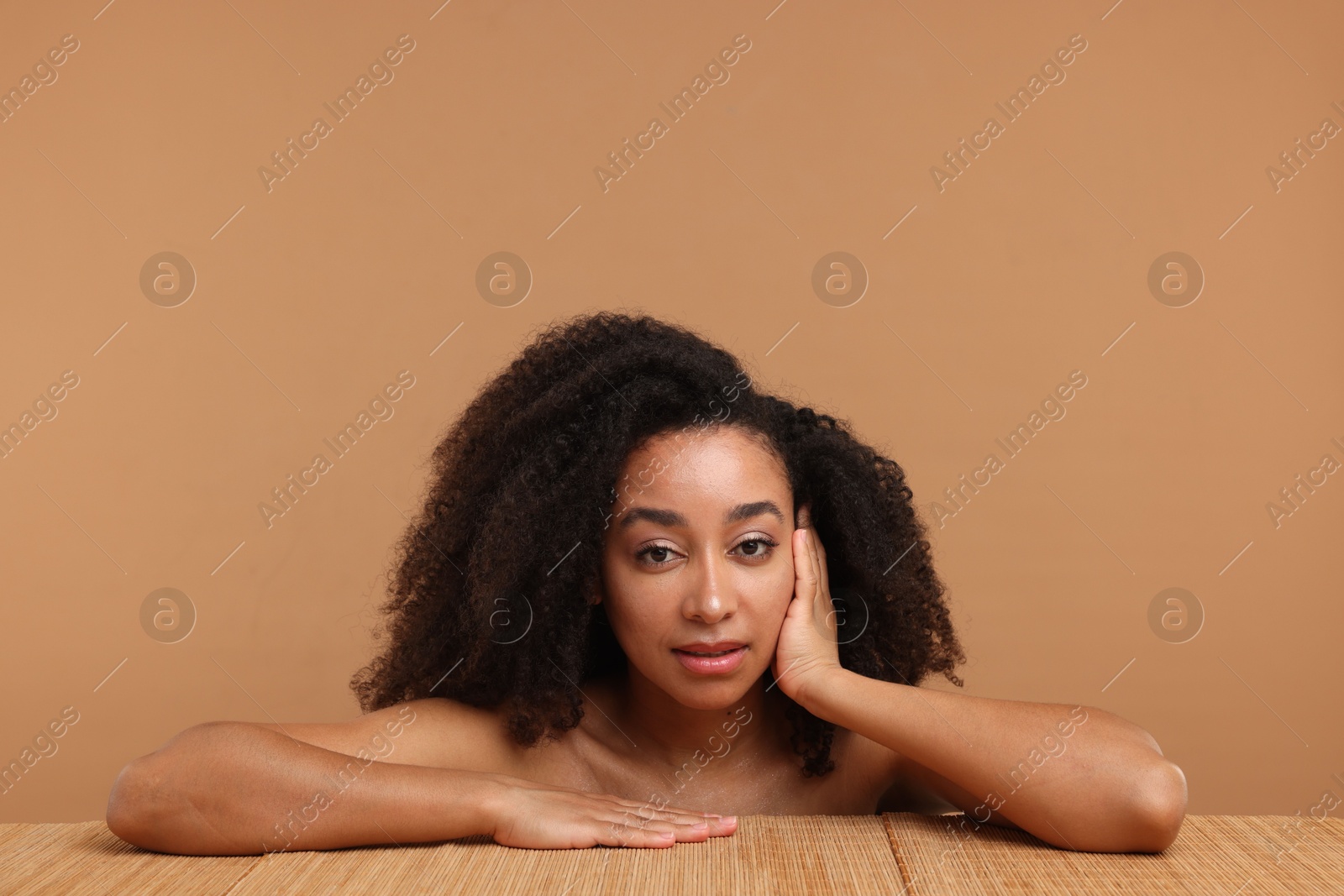 Portrait of beautiful Brazilian woman after spa treatment at bamboo table on beige background Photo of Portrait of beautiful Brazilian woman after spa treatment at bamboo table on beige background