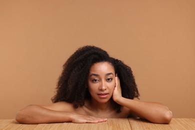 Photo of Portrait of beautiful Brazilian woman after spa treatment at bamboo table on beige background