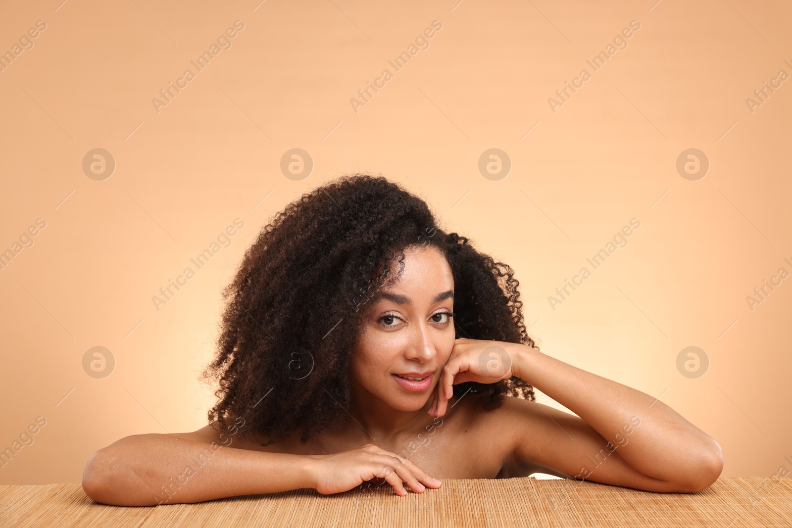 Portrait of beautiful Brazilian woman after spa treatment at bamboo table on beige gradient background Photo of Portrait of beautiful Brazilian woman after spa treatment at bamboo table on beige gradient background