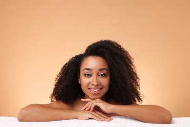 Photo of Portrait of beautiful Brazilian woman with towel after spa treatment on beige gradient background