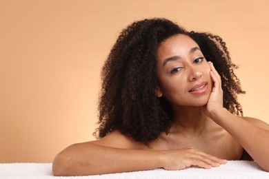 Photo of Portrait of beautiful Brazilian woman with towel after spa treatment on beige gradient background