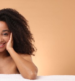 Photo of Portrait of beautiful Brazilian woman with towel after spa treatment on beige gradient background. Space for text