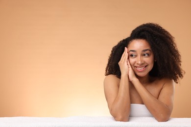 Photo of Portrait of beautiful Brazilian woman with towel after spa treatment on beige gradient background. Space for text