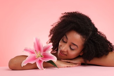 Photo of Portrait of beautiful Brazilian woman with lily flower after spa treatment on pink gradient background