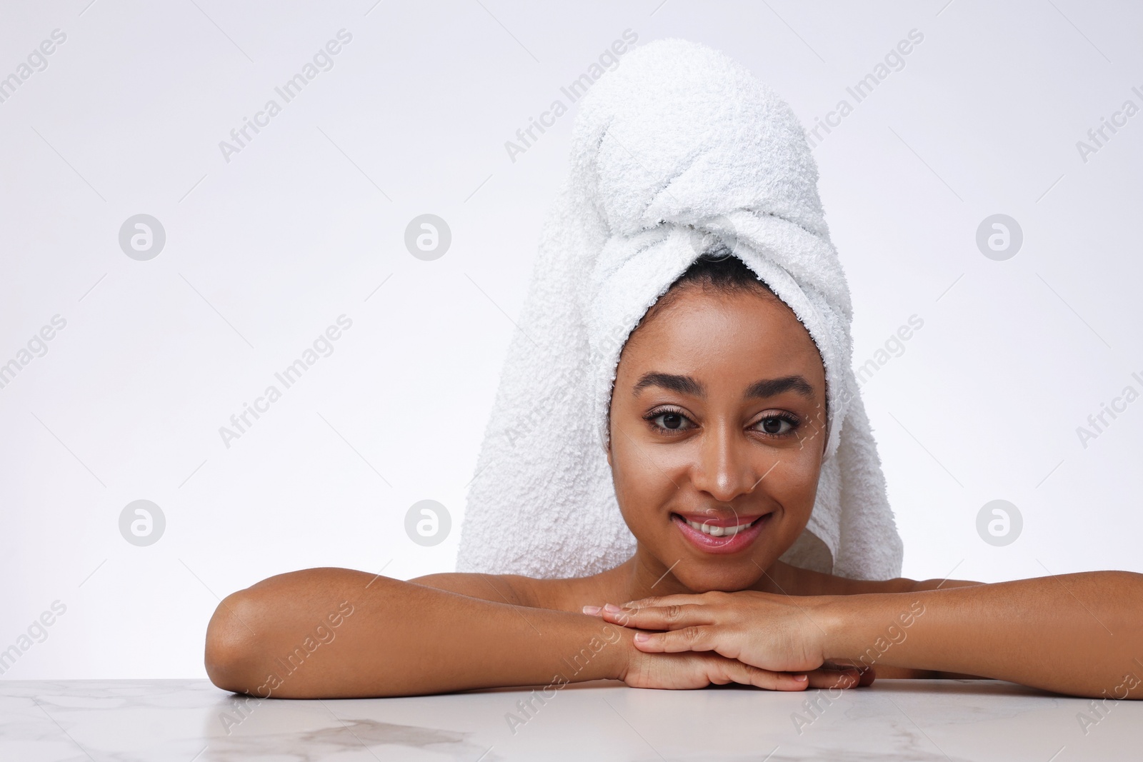 Portrait of beautiful Brazilian woman after spa treatment at gray marble table on light background Photo of Portrait of beautiful Brazilian woman after spa treatment at gray marble table on light background