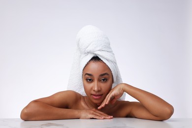 Photo of Portrait of beautiful Brazilian woman after spa treatment at gray marble table on light background