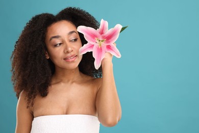 Photo of Portrait of beautiful Brazilian woman with lily flower after spa treatment on light blue background. Space for text