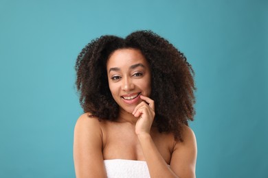 Photo of Portrait of beautiful Brazilian woman after spa treatment on light blue background